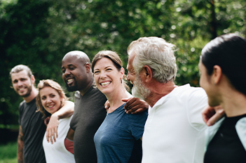 Group of people standing in a line side-hugging
